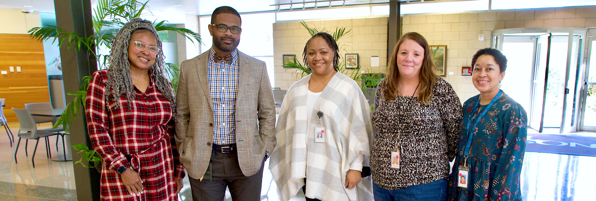 Five members of UNOS Member Quality team standing next to each other in the UNOS main lobby