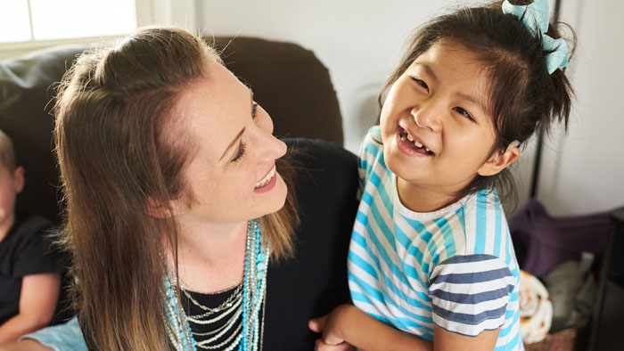 Transplant recipient, Abby, smiling with mom looking up at her