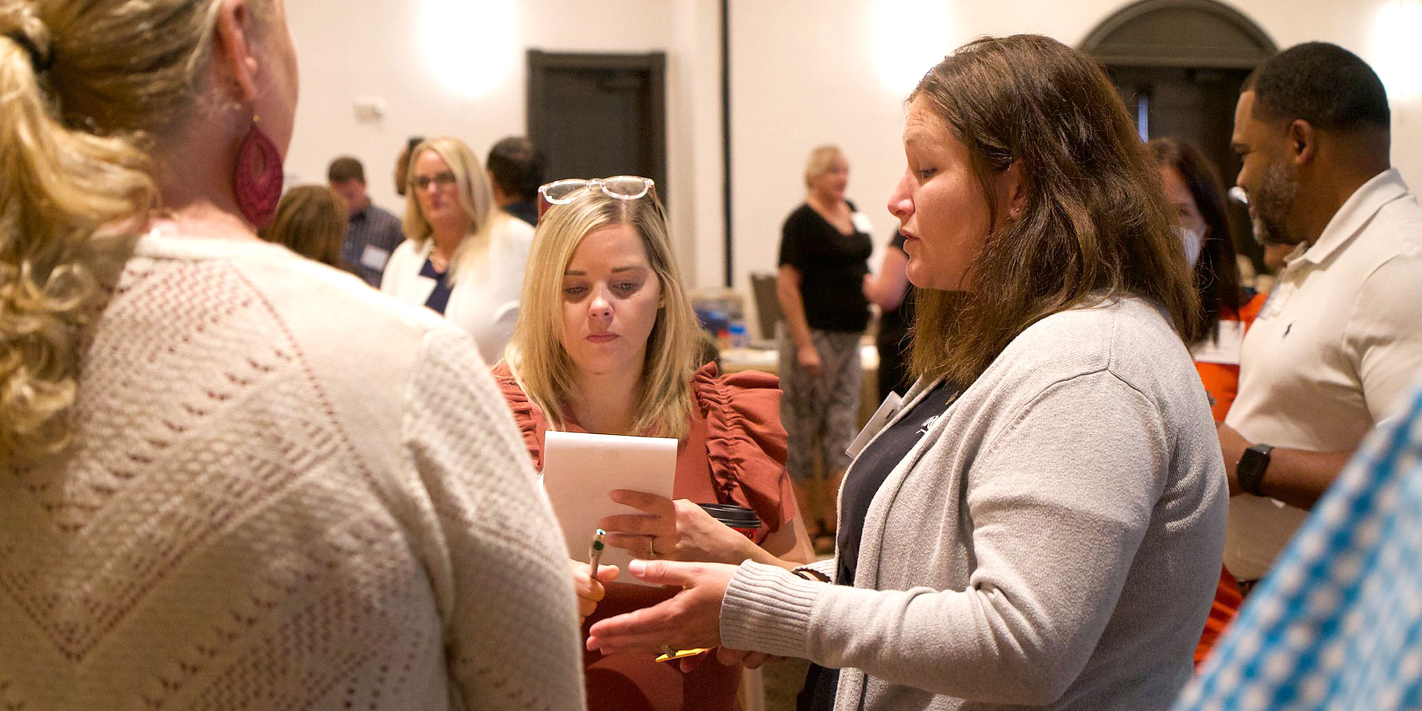 Collaborative improvement participants talking while standing in a conference space