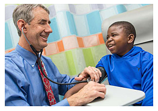 Marshall Jones, right, laughs with Dr. John Barcia of UVA Children's Hospital (Coe Sweet/UVA Health System via AP) 