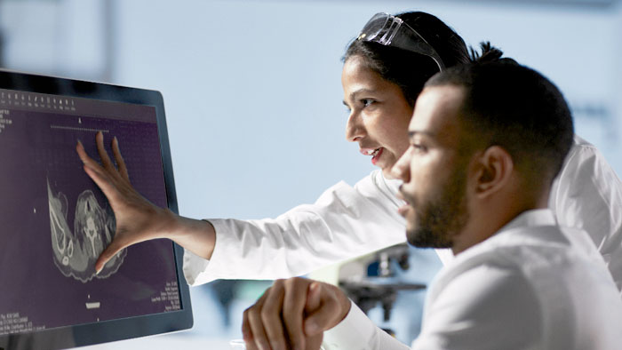 Two people looking at computer monitor of imaging study