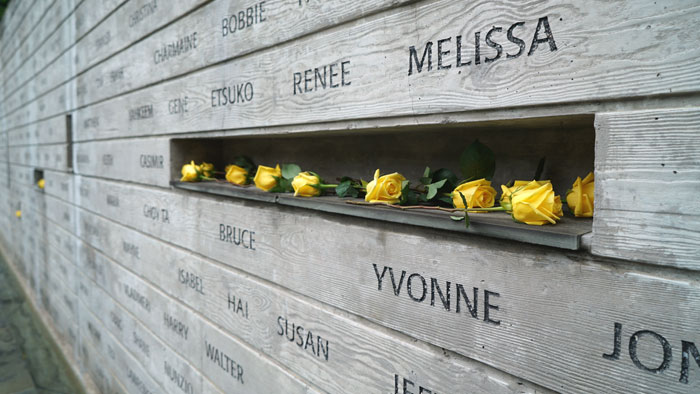Wall of names in National Donor Memorial with shelf holding yellow roses
