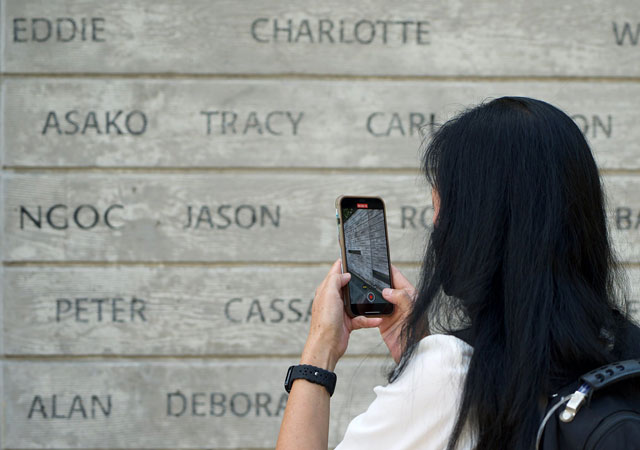 Woman taking a photo of the wall of names with her smartphone in the National Donor Memorial