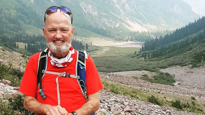 Transplant recipient David Skalski, smiling, with mountain range in background