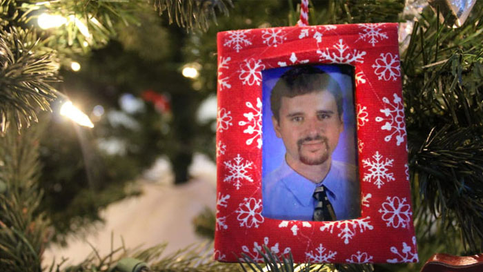 Red frame Christmas tree ornament with photo of Matt, organ donor