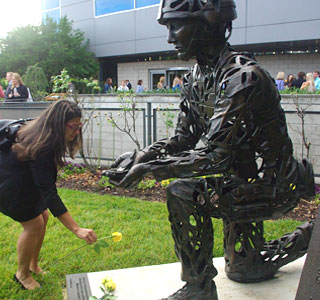 Macey Henderson places a rose on the UNOS Fallen Soldier Memorial (Photo: UNOS)